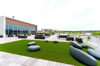 a roof terrace with grass and benches